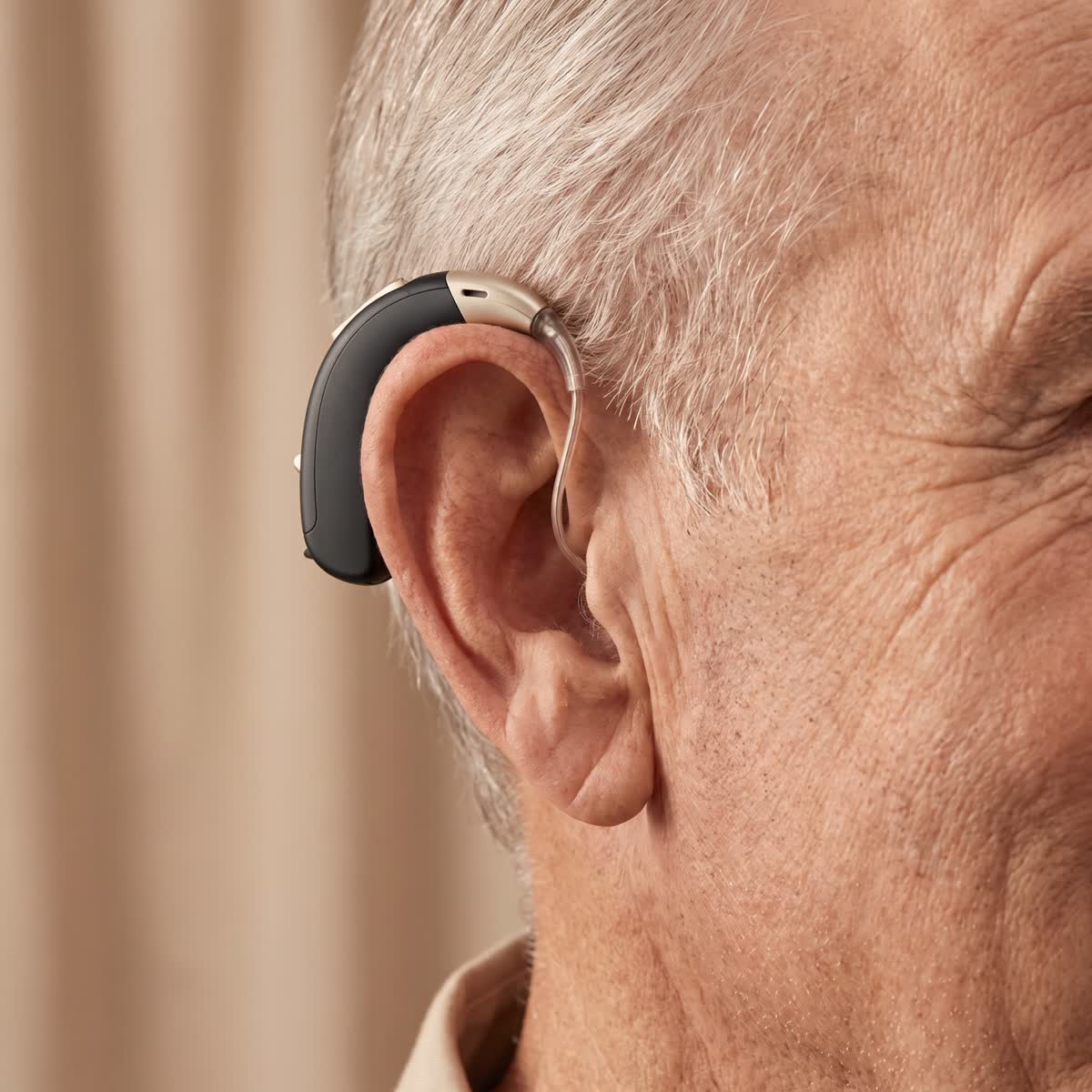 Gros plan d'un appareil auditif discret porté derrière l'oreille